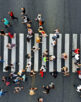 Aerial. People crowd motion through the pedestrian crosswalk. Top view from drone.