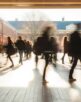 Crowd of students walking through a college campus on a sunny day, motion blur