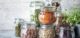 Set of different legumes in glass jars on, concrete white table. A source of protein for vegetarians. The concept of healthy eating and food storage.