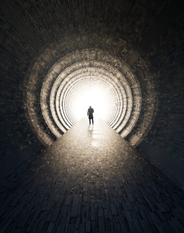 Concept or conceptual dark tunnel with a bright light at the end or exit as metaphor to success, faith, future or hope, a black silhouette of walking man to new opportunity or freedom 3d illustration