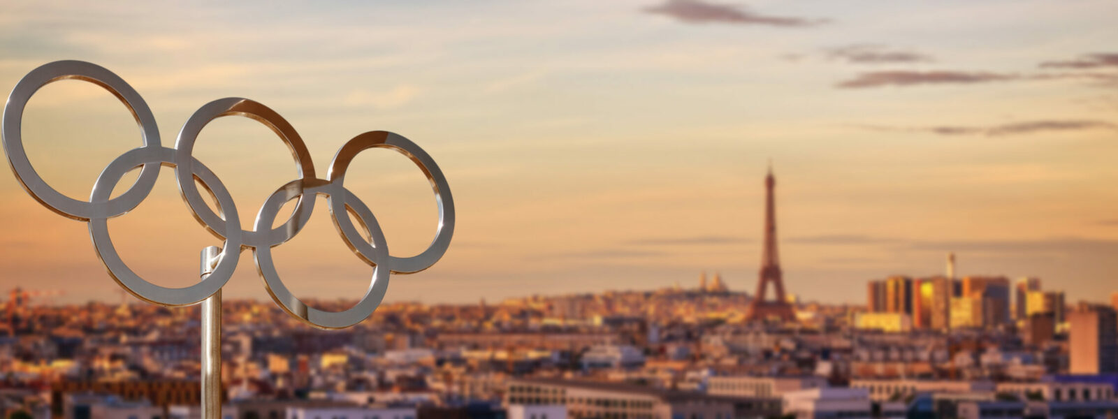 Olympic rings  at sunset with the Eiffel tower in Paris France panoramic background, Paris 2024 summer olympic games web banner