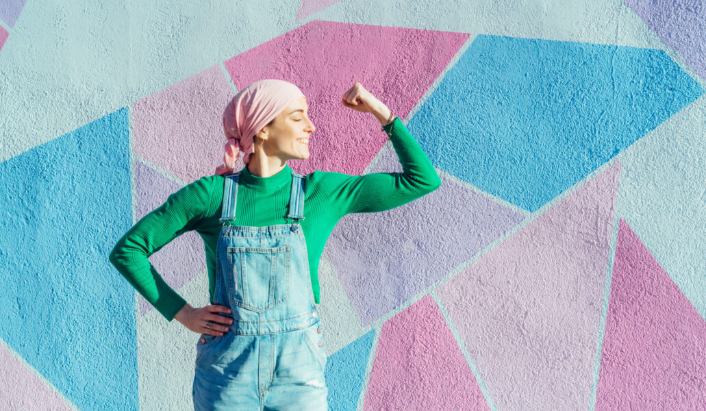 Portrait of woman with pink headscarf, has cancer. Show the arm as a signal of strength