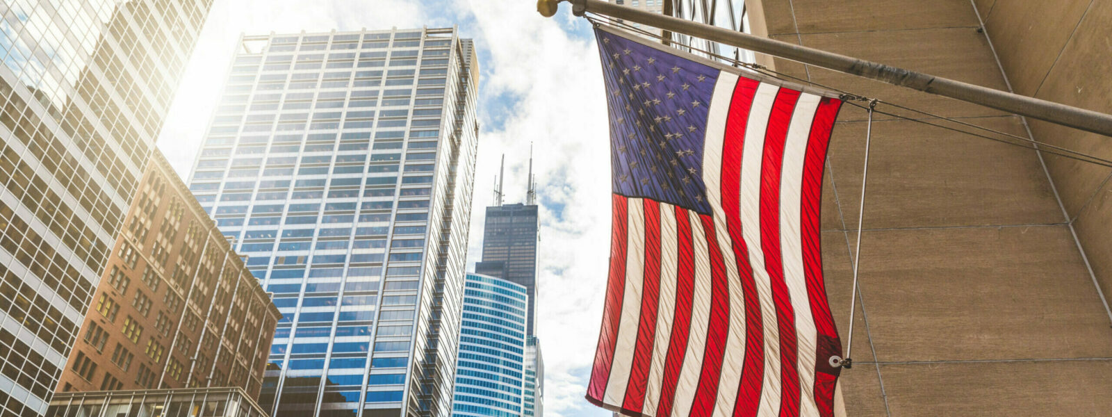 USA flag in Chicago with with skyscrapers on background