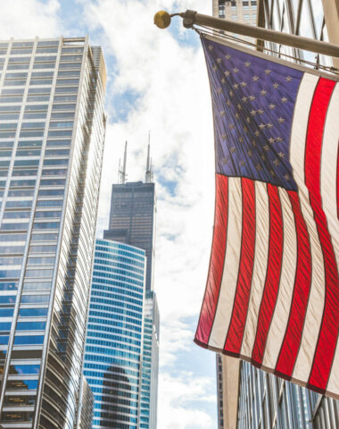 USA flag in Chicago with with skyscrapers on background